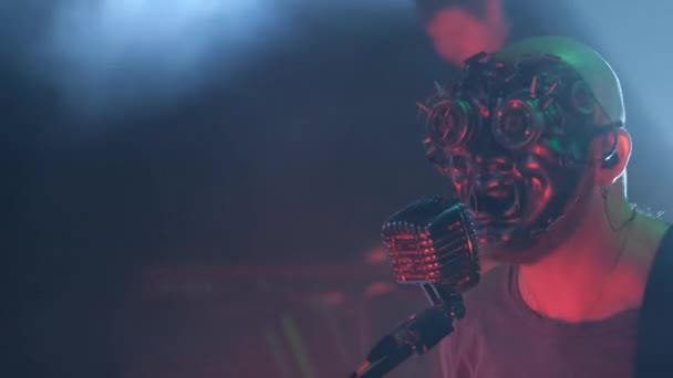 一个很酷的摇滚歌手带着面具在舞台上演唱 并被红色霓虹灯照亮 4K视频 — 图库视频影像
