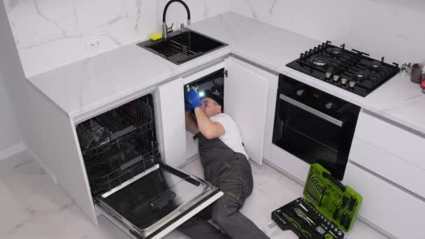 一个管道工躺在厨房的地板上 他安装了一个水槽 管道工的工作4K视频 — 图库视频影像
