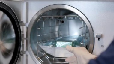 Kadın bir hemşire klinikte çalışıyor ve tıbbi aletleri sterilize ediyor. Cerrahi operasyonlar için hazırlık. Modern klinik