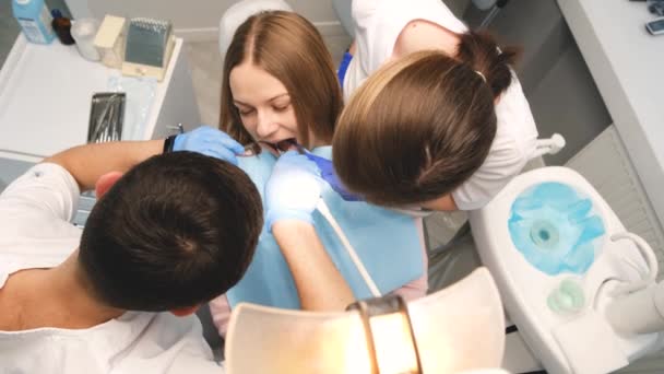 Zwei Ärzte Schutzmasken Einer Zahnklinik Die Einer Patientin Helfen Gesundheits — Stockvideo