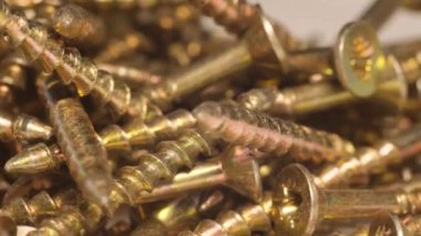 Masa makro videosundaki vidaları ve vidaları kendi kendine vuruyorsun. Vidaya süper yakınlaş. Metal vidaların reklamı