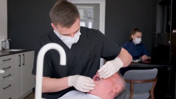 Ein Zahnarzt Setzt Einem Älteren Mann Moderne Zahnimplantate Ein Zahnbehandlung — Stockvideo