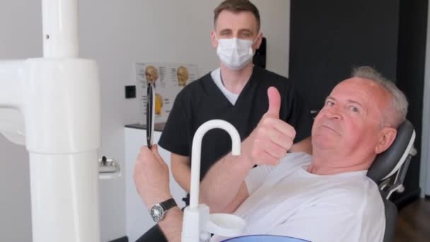 Szczęśliwy Uśmiechnięty Starszy Mężczyzna Badany Przez Dentystę Siedzący Krześle Kliniki — Wideo stockowe