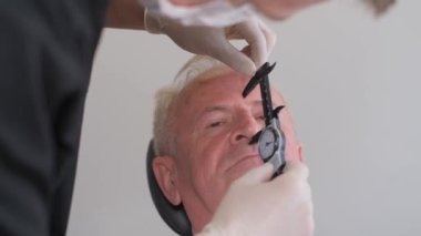 Doktor cerrahın portresi erkek yüzünde iz bırakıyor, yaşlı adam. Yüksek kalite 4k video