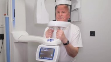 Sefalometrik üniteli diş röntgeni makinesi yaşlı bir adamın yüzünün fotoğrafını çekmesi. 3B görselleştirme