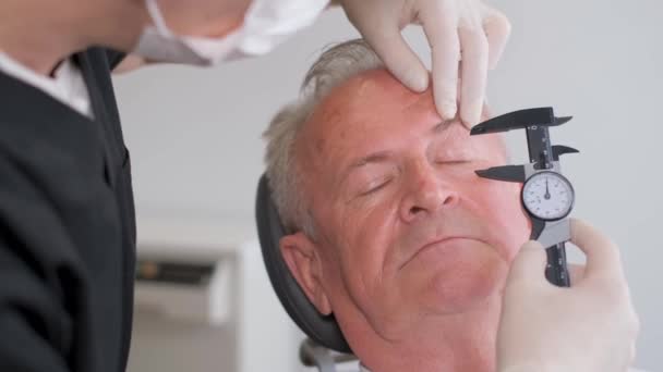 整形外科医は さらに手術のために老人の顔に印を付けます 現代の整形手術 高品質4Kビデオ — ストック動画