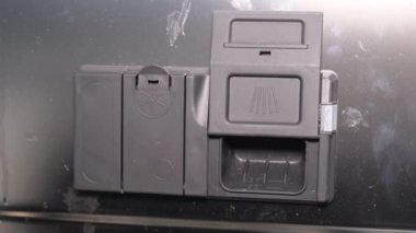 Bir kadın eli bulaşık makinesinin içine kimyasal tablet yerleştirir. Modern teknolojileri kullanarak yüksek kaliteli bulaşık yıkama