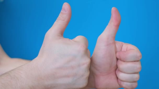 Twee Mannelijke Handen Die Duimen Laten Zien Een Helderblauwe Achtergrond — Stockvideo