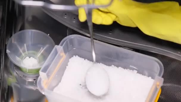 一个人拿着橡胶手套 用勺子把粉末倒入洗碗机的容器里 高质量洗碗用的化学方法 洗碗液 — 图库视频影像