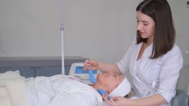 Güzel bir kadın deri kaldırmak için yüz mikro akımı ameliyatı oluyor. Mikro akım terapisi.