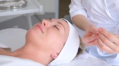 Bir kozmetolog yüz yenileme için enjeksiyon prosedürü uygular. Modern bir güzellik salonunda yüz bakımı