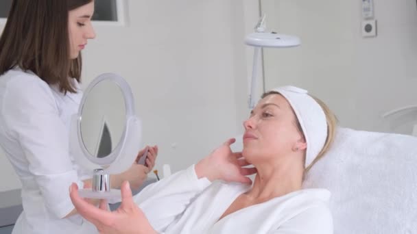 미용사는 미용실에서 여자들의 얼굴에 마스크를 씌우고그와 의사소통을 고품질 비디오 — 비디오