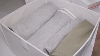 Tekstil çantası ve katlanmış elbiseli bir organizatör. Düzen ve depolama kavramı. Dikey depolama yöntemi. Yukarıdan görüntüle.