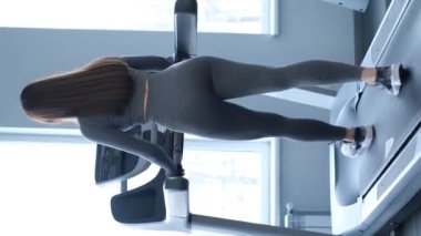 Spor salonunda yavaş adımlarla koşu bandında egzersiz yapan aktif bir kadın. Spor salonunda çalışan fitness kızı.