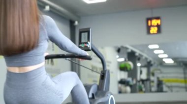 Kadın sporcu simülatörde antrenman yapıyor. Spor salonunda çalışan fitness kızı..