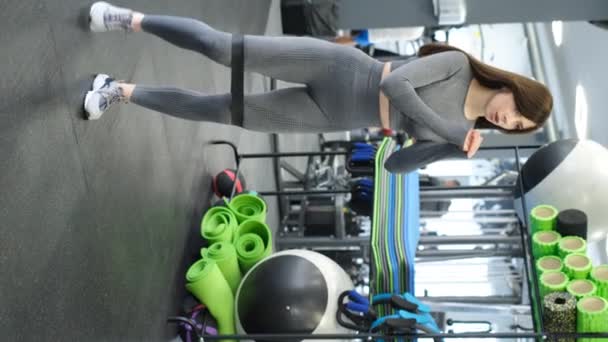 Asyalı Kız Spor Salonunda Lastik Bant Ile Bacak Kaslarını Çalıştırıyor — Stok video