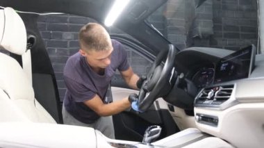 Arabanın içini profesyonel olarak temizliyor, arabanın içini süpürüyor. Araba kuru temizleme. Araba servisi..