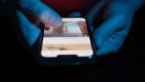 一个男人的手在智能手机的屏幕上快速地移动着他的手指 在网上搜寻什么东西 男性手 手持蓝光智能手机 — 图库视频影像