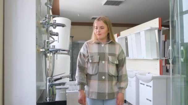 アメリカ人の女性は自宅の浴室のための配管器具を選ぶ アパートの改装コンセプト 4Kビデオ — ストック動画