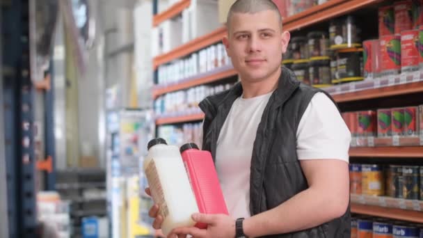 Hırdavatçıdaki Bir Satıcı Elinde Boya Kutuları Tutuyor Bir Hırdavatçıda Satış — Stok video