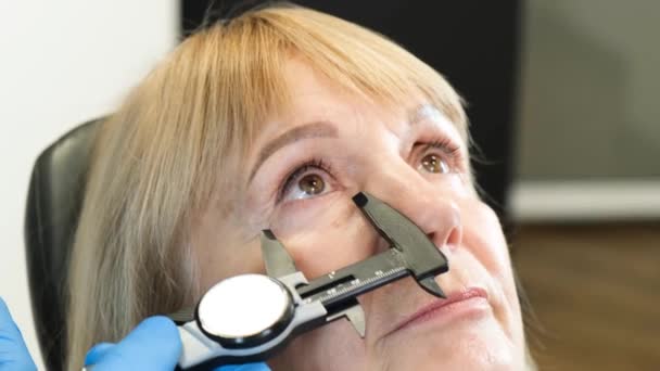Läkare Förbereder Äldre Kvinna För Plastikkirurgi Ansiktet Perforering Ansiktet Före — Stockvideo
