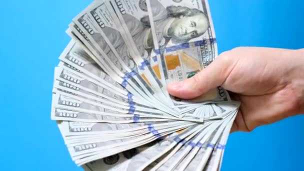 Birçok 100 Dolarlık Banknotlar Mavi Arka Plandaki Bir Adamın Ellerinde — Stok video