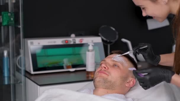 Cosmétologue Effectue Massage Facial Avec Masque Argile Appliqué Sur Visage — Video