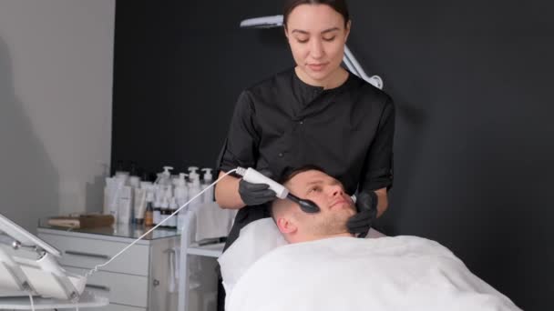 피부를 깨끗하게 얼굴에 붙이는 초음파 장치로 처리하 남성의 여드름 온천에서 — 비디오