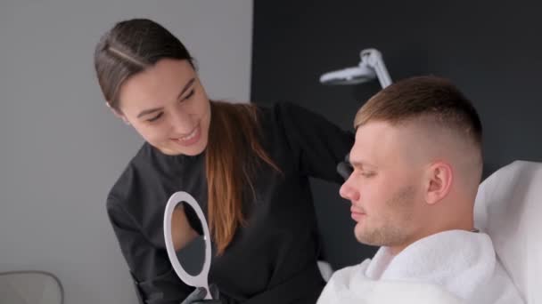 プロの美容師に顔を検査された温泉の男 男性化粧品 モダンなスパサロン — ストック動画