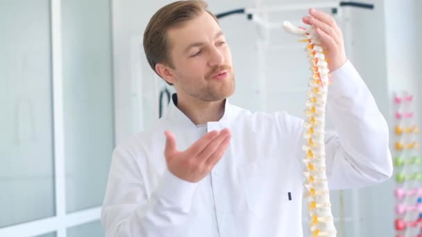 一位脊椎学家通过展示脊柱的骨架来说明如何治疗背部 — 图库视频影像