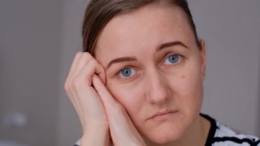 Üzgün, dalgın genç bir kadının yakın plan fotoğrafları, yalnız başına oturan, ilişkileri düşünen, kişisel sorunları olan. Bir kadın evde kendini yalnız, depresif hisseder, düşünür ya da özler.