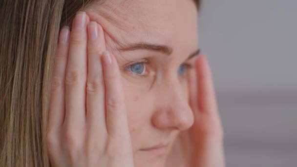 一个女人低着头担心头疼得无法忍受 坐在家里的沙发上 失眠会导致头痛 靠近点 — 图库视频影像