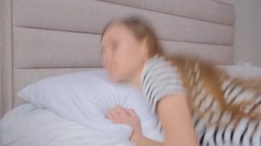 Yorgun bir kadın yatakta uyur. Zor bir gündü. Evde dinlen..