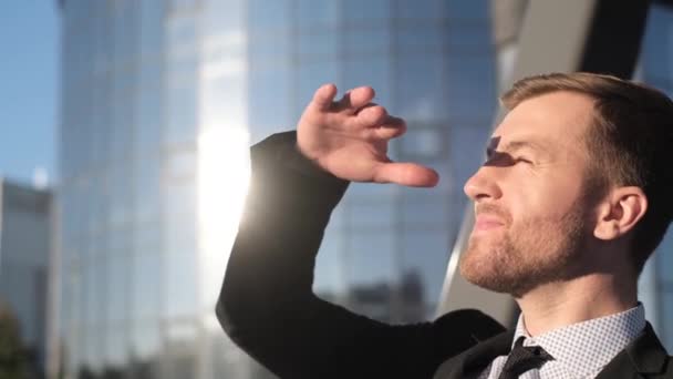 기업의 지도자는 손으로 자신을 가리고 태양을 바라봅니다 — 비디오
