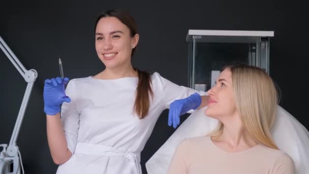 美容室で美女の唇や顔に美容師の女の子が注射 化粧品学の概念 — ストック動画