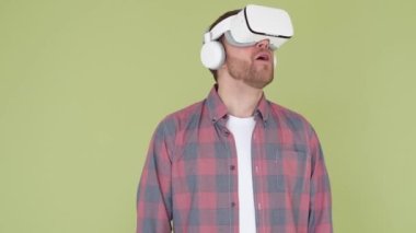 Stüdyoda sanal gerçeklik gözlüğü takan sakallı adam. VR kulaklıklı bir akıllı telefon kullanmak. Modern teknoloji