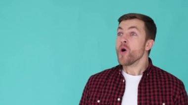 Şaşırmış kırmızı tişörtlü genç adam şaşkınlıkla başka tarafa bakıyor..