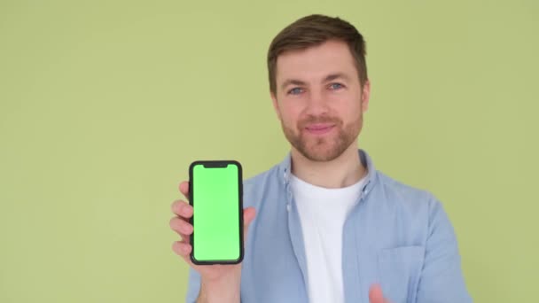 緑の画面を持つスマートフォンを持っている若い男のクローズアップ肖像画 — ストック動画