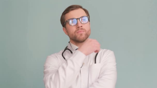 Серйозний Вдумливий Бородатий Лікар Стоїть Синьому Фоні Медичній Формі Знімок — стокове відео