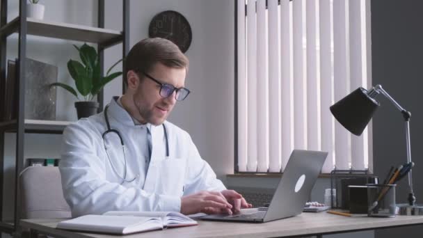 Médico Serio Concentrado Gafas Uniforme Trabaja Oficina Computadora Trabajo Electrónico — Vídeos de Stock