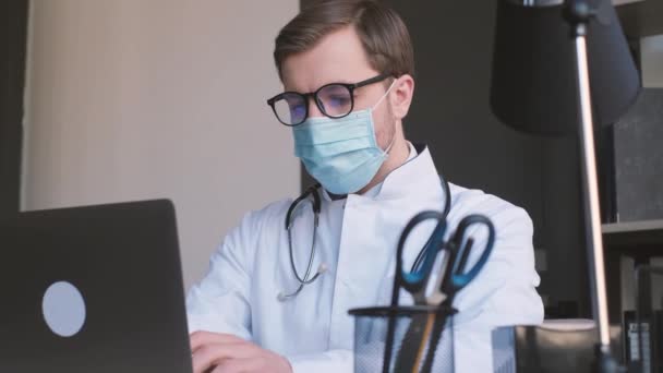 Young Doctor Medical Mask Glasses Working Netbook His Office Infertsionist — Stock Video
