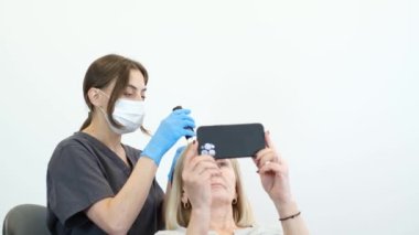 Doktor saç yapısına teşhis koyuyor. Yaşlı bir kadının trikoloğa danışması.
