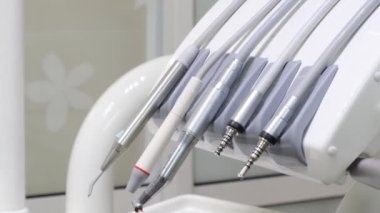 Diş sandalyesindeki diş aletlerinin yakın plan görüntüsü. Dişlerle çalışmak için steril, metal aletler. Diş tedavisine modern yaklaşımlar.