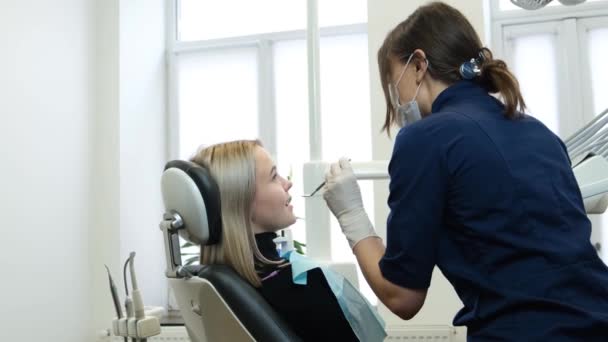 在现代牙科诊所治疗年轻妇女牙齿的过程 年轻的专业牙医治疗病人的牙齿 — 图库视频影像