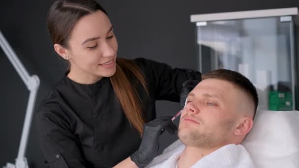 一个年轻的欧洲人得到了一位做肉毒杆菌注射的美容师 男性面部皮肤的再生 男性化妆品学 — 图库视频影像