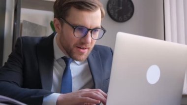 Şaşırmış ve mutlu bir bilişim işçisi. Takım elbiseli bir programcı ofisteki bir bilgisayarda çalışıyor. Başarı duyguları, sevinç