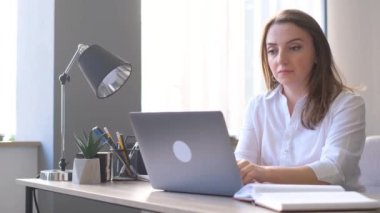 Ofiste çalışan kadın ofis müdürü. Ofiste çalışan kadın dizüstü bilgisayarın başında oturuyor. 4k video