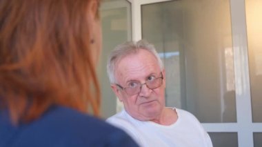 Bir kardiyolog klinikte yaşlı bir adama danışıyor. Kalp hastalıkları. Dikey video