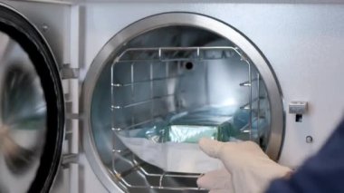 Kadın bir hemşire klinikte çalışıyor ve tıbbi aletleri sterilize ediyor. Cerrahi operasyonlar için hazırlık. Modern klinik