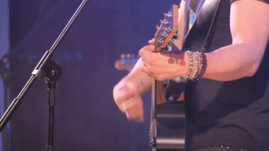 Bir gece kulübünde akustik gitar çalan caz gitaristi. Adam bu enstrümanı çalmak için ellerini kullanıyor, bu da ona gitar çalma yeteneği veriyor. Dikey video